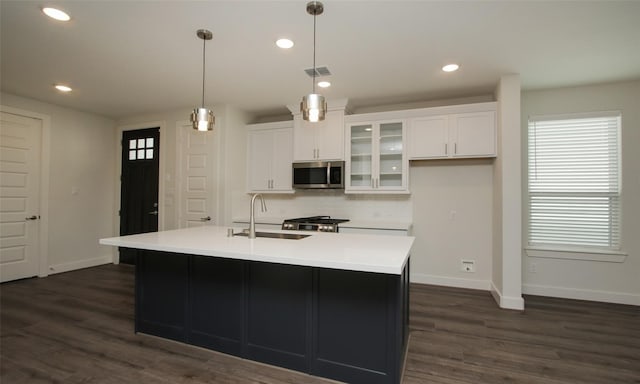 kitchen featuring white cabinetry, pendant lighting, dark hardwood / wood-style flooring, and a center island with sink