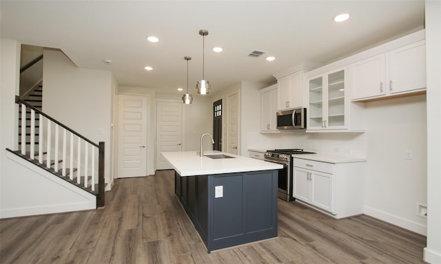 kitchen with white cabinetry, an island with sink, appliances with stainless steel finishes, decorative light fixtures, and sink