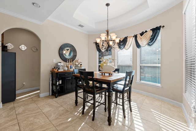 dining room featuring an inviting chandelier, crown molding, and a raised ceiling