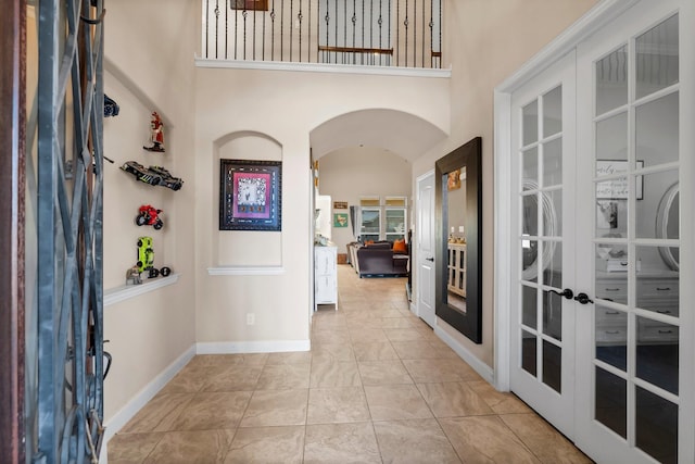 entrance foyer with french doors and a high ceiling