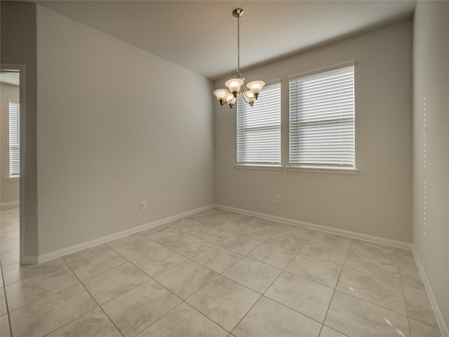 spare room with light tile patterned floors and an inviting chandelier