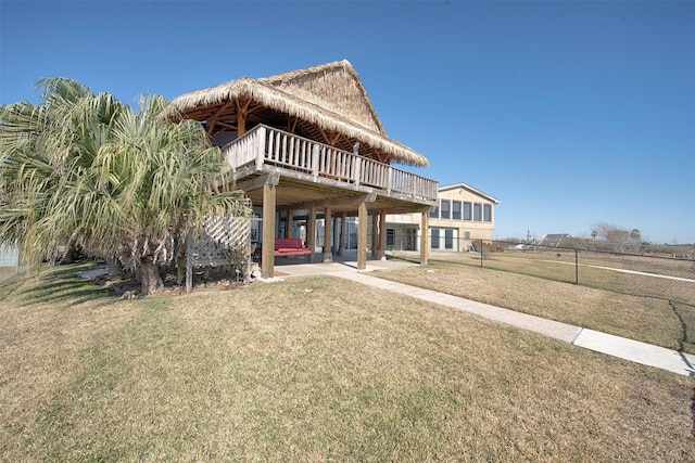 back of house with fence, a lawn, and a wooden deck