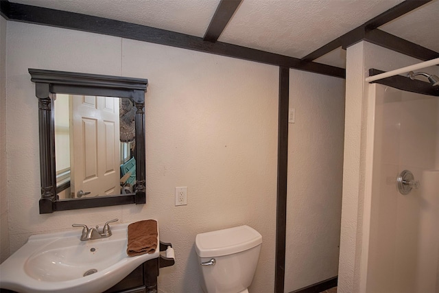 full bath featuring a textured wall, toilet, a stall shower, a textured ceiling, and vanity