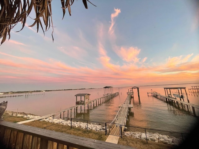 view of dock featuring a water view and fence