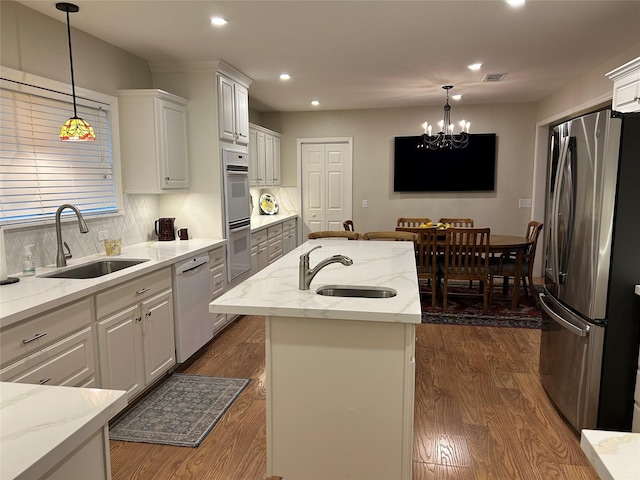 kitchen featuring freestanding refrigerator, a sink, dishwashing machine, recessed lighting, and dark wood-style floors