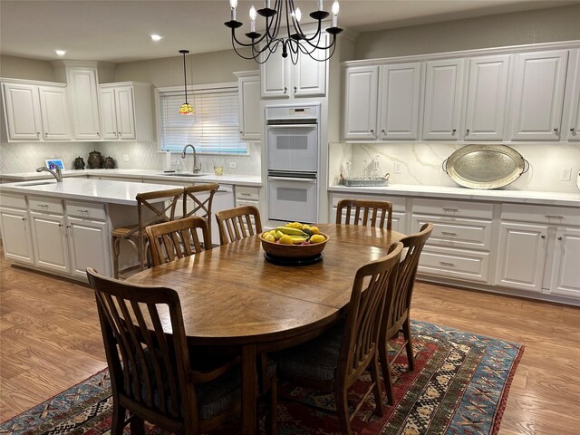 dining area featuring light wood-style floors, recessed lighting, and a chandelier
