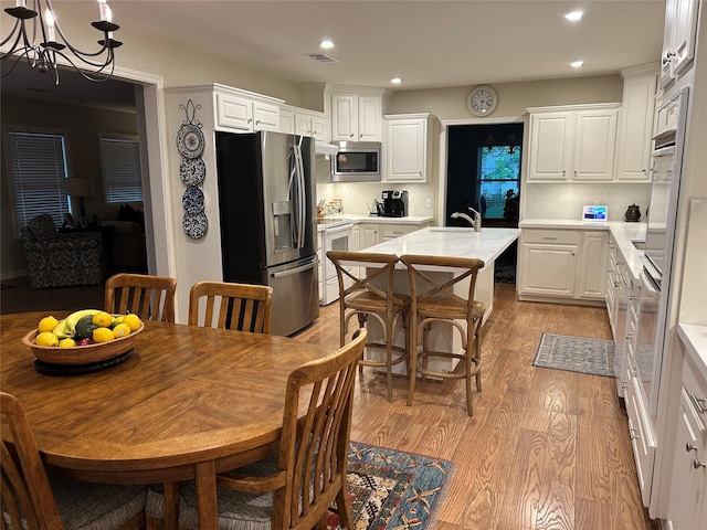 dining space with light wood-style floors, a chandelier, and recessed lighting