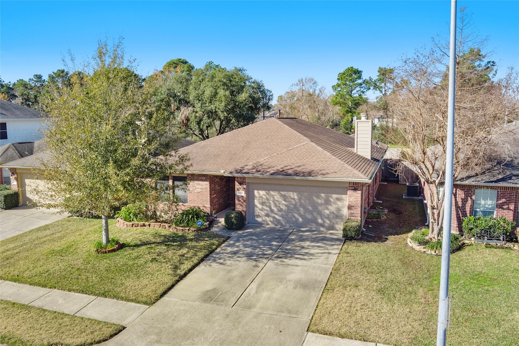 single story home with a garage and a front lawn