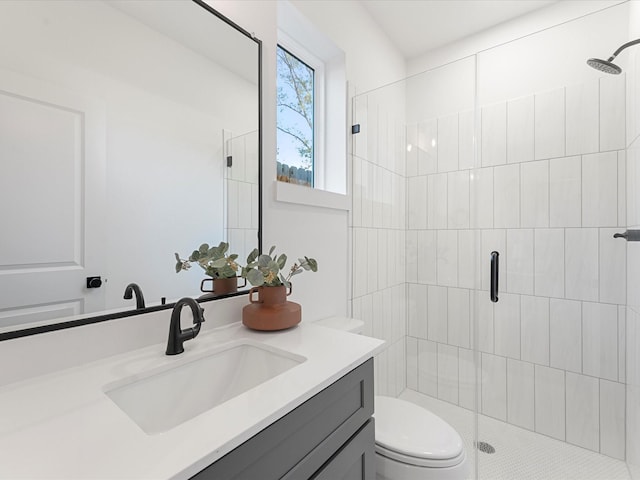 bathroom with a shower with door, toilet, and vanity