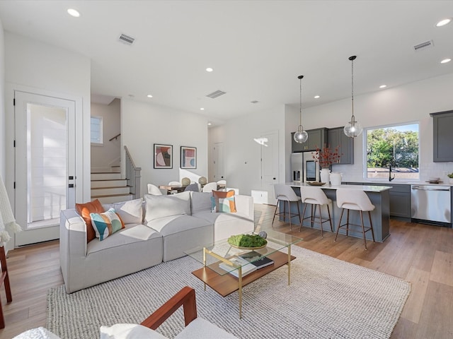 living room with sink and light hardwood / wood-style flooring