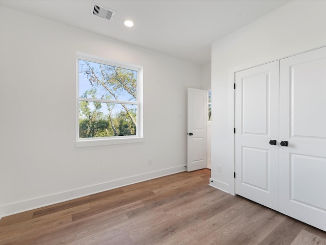 unfurnished bedroom featuring a closet and light hardwood / wood-style floors