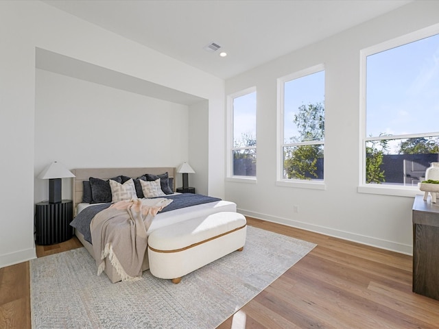 bedroom featuring multiple windows and light wood-type flooring