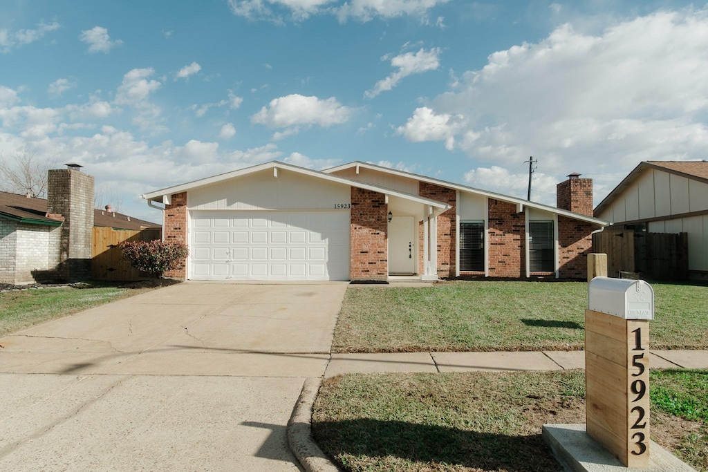 ranch-style house featuring a garage and a front lawn