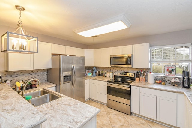 kitchen with pendant lighting, sink, white cabinets, and appliances with stainless steel finishes