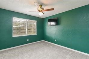 carpeted empty room with ceiling fan and a healthy amount of sunlight