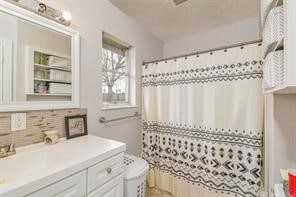 bathroom featuring toilet, vanity, and a shower with shower curtain