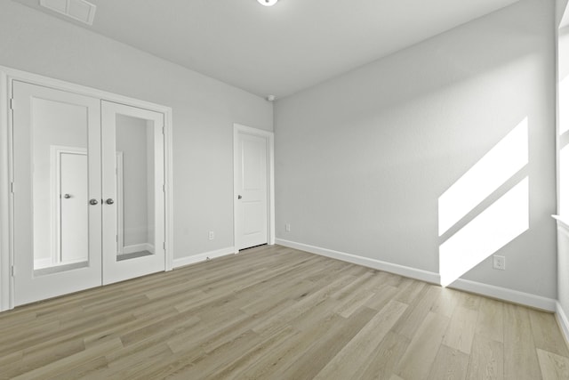 unfurnished bedroom with visible vents, light wood-type flooring, and baseboards