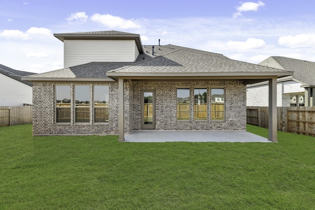 rear view of house with a patio area, a fenced backyard, brick siding, and a lawn