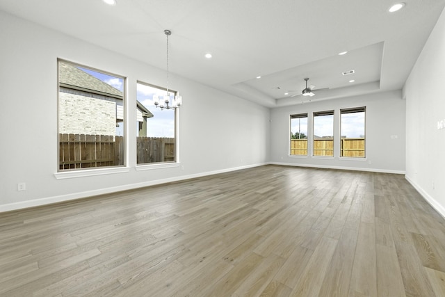 unfurnished living room featuring recessed lighting, a raised ceiling, and wood finished floors