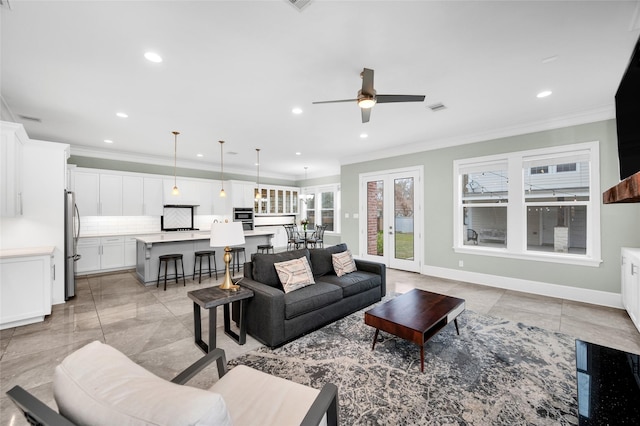 tiled living room with crown molding, ceiling fan, and french doors