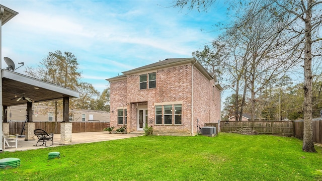 rear view of house with central air condition unit, a patio area, and a yard