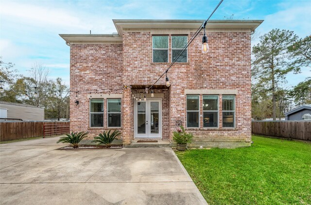 rear view of house with a patio and a yard