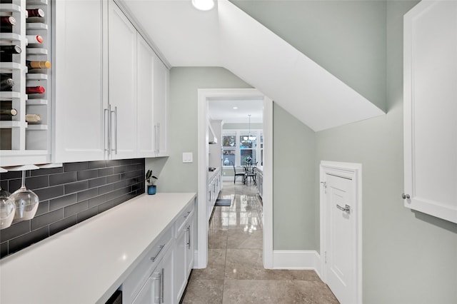 bar featuring backsplash and white cabinets