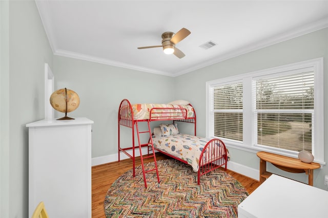 bedroom featuring ceiling fan, crown molding, and hardwood / wood-style flooring