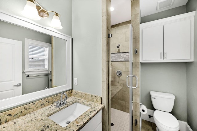 bathroom featuring vanity, toilet, and a shower with door