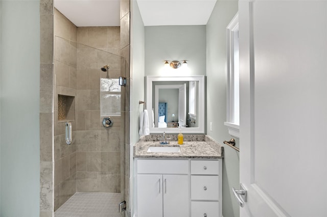 bathroom with a shower with shower door and vanity