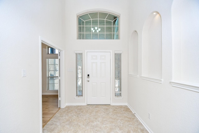 entryway featuring a towering ceiling and plenty of natural light