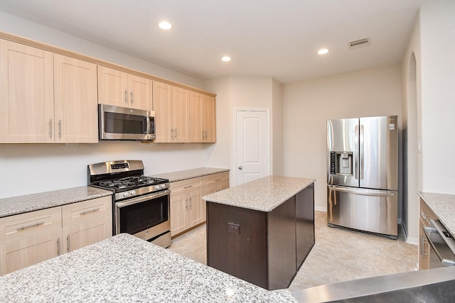 kitchen featuring light brown cabinets, light stone countertops, and appliances with stainless steel finishes