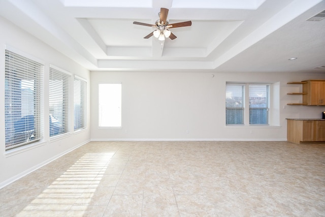 unfurnished living room featuring a raised ceiling, light tile patterned floors, and ceiling fan