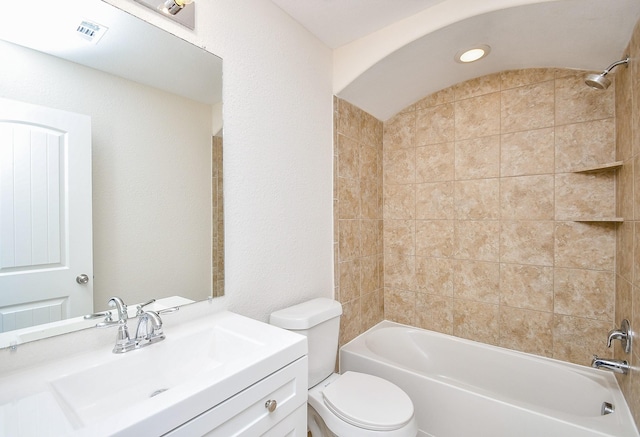 full bathroom with vanity, tiled shower / bath combo, lofted ceiling, and toilet