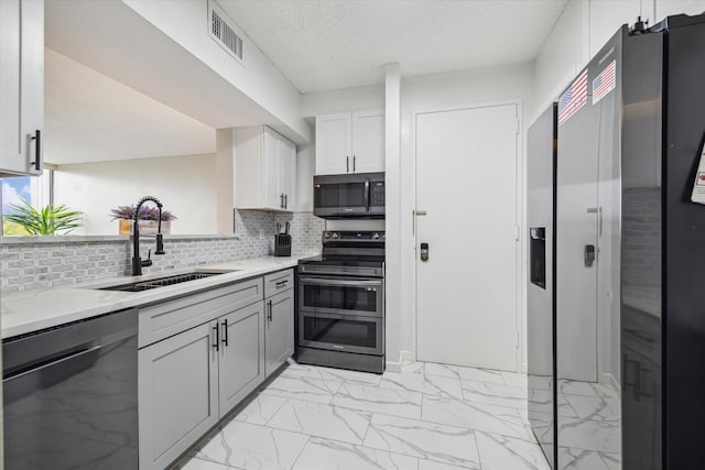 kitchen featuring appliances with stainless steel finishes, white cabinetry, sink, backsplash, and gray cabinetry