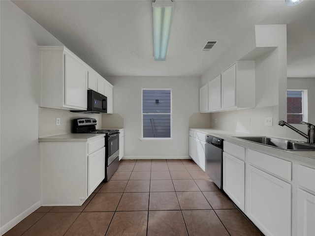 kitchen featuring sink, stainless steel appliances, white cabinetry, and tile patterned floors