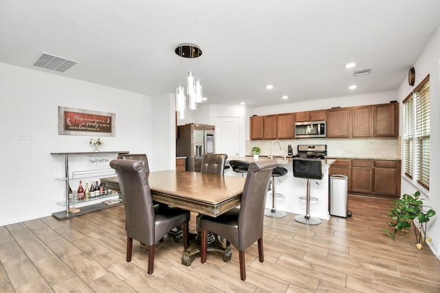 dining space with sink and a notable chandelier