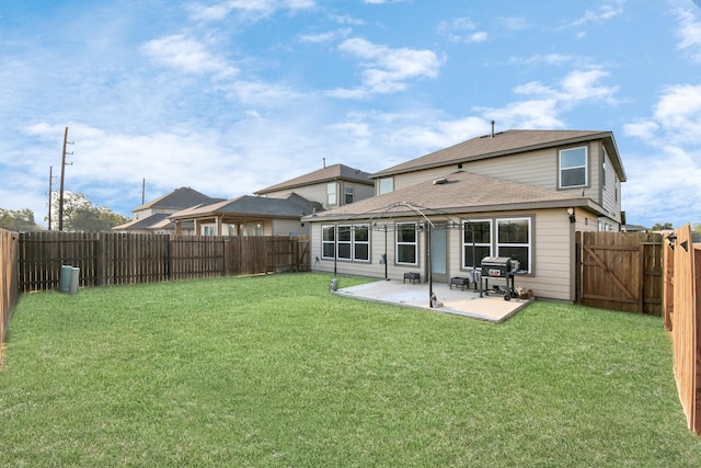 rear view of property with a lawn, a gazebo, and a patio