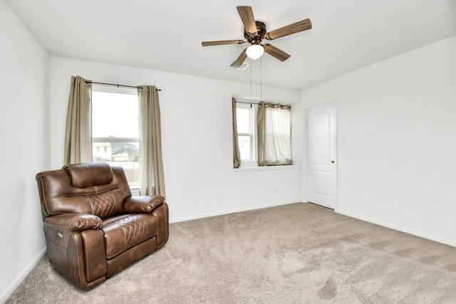 sitting room with ceiling fan and light colored carpet