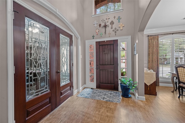 foyer with crown molding and hardwood / wood-style flooring