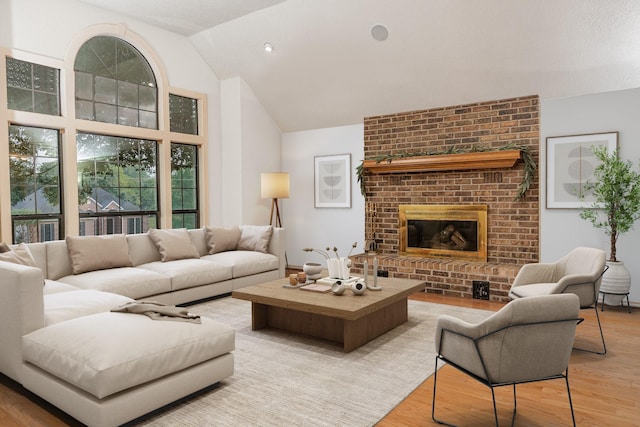 living room with a fireplace, lofted ceiling, and light hardwood / wood-style floors