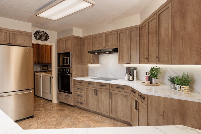 kitchen featuring decorative backsplash, washer and clothes dryer, and black appliances