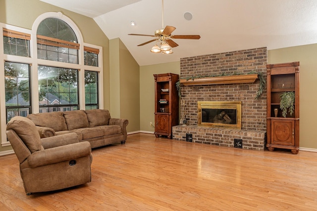 living room featuring light wood-type flooring, ceiling fan, lofted ceiling, and a fireplace