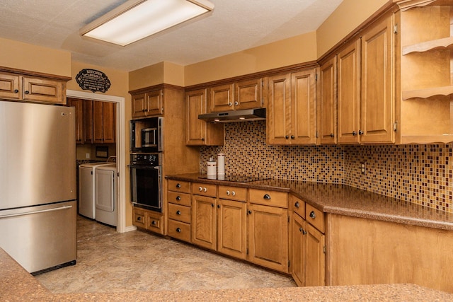 kitchen with black appliances, backsplash, and independent washer and dryer