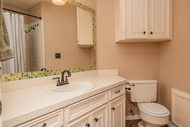 bathroom featuring toilet, vanity, and a shower with curtain