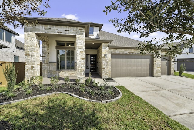 view of front of house featuring stone siding, driveway, and a garage