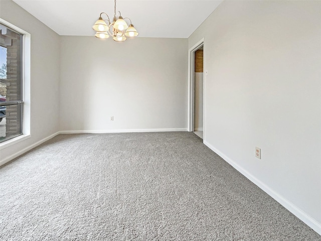 spare room with carpet and an inviting chandelier