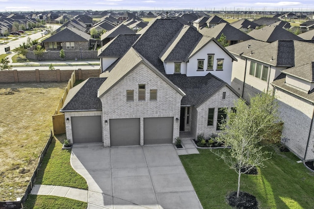 view of front facade featuring a front yard, a residential view, driveway, and a shingled roof