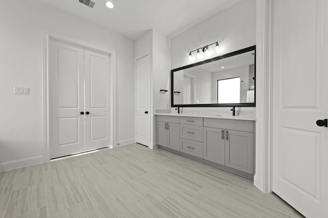 full bathroom with recessed lighting, a sink, baseboards, and double vanity