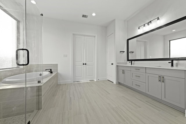 full bath featuring a garden tub, a sink, visible vents, a shower stall, and double vanity